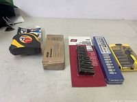 Full lot of four tool accessories including tape measure and socket sets.