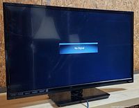 Front view of the 32-inch Vizio LED TV powered on showing 'No Signal' message on screen.