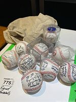 Nine baseballs including eight signed and one unsigned Boston Red Sox baseball, some in display cases and some wrapped in plastic.