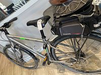 Grey Giant touring bicycle on floor, showing frame, wheels, saddle and handlebar