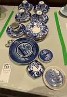 Full set of cups, saucers, plates, and small decorative dishes displayed on table.