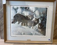 Framed print showing full artwork with three wolves in a snowy forest scene, showcasing the frame and overall condition.