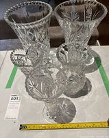 Photo showing all four crystal glass vases together, different shapes and cut patterns visible.