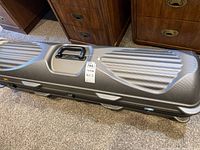 Full exterior view of the rectangular, textured hard case with handle and latch visible.