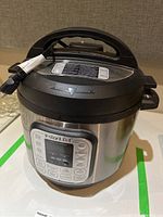 Instant Pot Duo 7-in-1 electric pressure cooker showing front control panel and lid with handle.