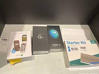 Top-down view of four boxes: Doro PhoneEasy 626, LG Q6, Moto G Stylus, Raspberry Pi Starter Kit