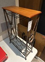 Side angled view of wine rack showing metal frame, wood top, and bottle holders.