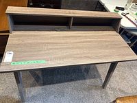 Front angle showing the desk surface and built-in shelf divided into two compartments.