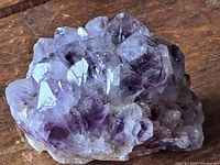 Close-up image of amethyst crystal rock showing purple crystal points and rough base.