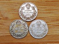 Top view of the reverse of the three Canadian 10 cent coins dated 1913, 1920, and 1931 showing the crown and maple leaf wreath design.