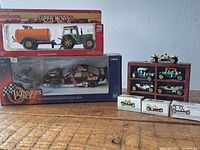 Photo shows collection of diecast model cars and tractor toy, some new in box
