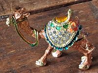 Side view of the camel trinket box showing the colorful jewels and enamel decoration on the saddle.