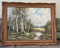 Full view of framed landscape painting showing birch trees by a pond and mountains in background