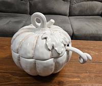 Closed view of the white ceramic pumpkin shaped soup tureen with leaf detail on lid and a curled vine handle.