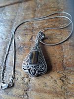 Front close-up showing pendant's detailed design and tiger's eye stone