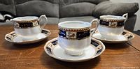 Three Royal Albert Trigo pattern tea cups with matching saucers arranged on a table.