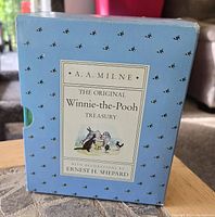 Front view of light blue slipcase with bees pattern and label reading 'A.A. Milne The Original Winnie-the-Pooh Treasury with decorations by Ernest H. Shepard'.