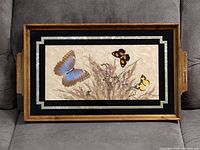 Full view of the wood serving tray with butterfly inlay and glass cover, showing the integrated handles and wood frame.