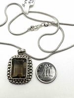 Close-up image of pendant and chain alongside a Canadian dime to show scale.