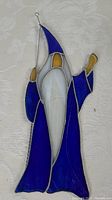 Front view of stained glass window hanger showing the full figure in blue, white, and yellow glass.