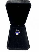 Open black velvet box showing ring nestled inside