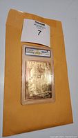 Front view of 1995 23 karat gold Joe Montana collector's card encapsulated in WCG graded plastic holder with label showing grading 10 and serial number.