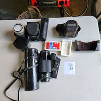 Contents of lot displayed on table, showing lenses, cases, auto winder, and filters