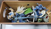 Wooden box containing multiple dragon figures of fire and ice theme Mega Bloks set