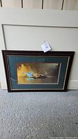 Framed Spitfire print resting against a door, showing entire frame, artwork, and matting.