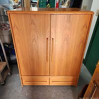 Closed teak wood TV cabinet showing front with double doors and two drawers below