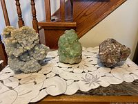 All three specimens displayed on a lace tablecloth in front of wooden stairs