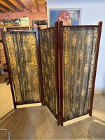 Front-angle view of the folding three-panel room divider showing the fabric patterned panels and wood frame.