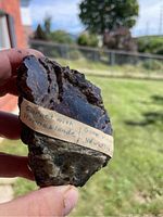Front view of mineral specimen showing garnet crystals and a label indicating 'Garnet with Hornblende, Gore Mountain, New York'.