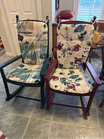 Two rocking armchairs side-by-side, each with cushions tied to the backs and seats, placed on tiled floor indoors.