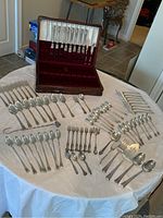 Full spread of all flatware pieces on table with open wooden case