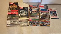 Photo of stacked vintage Life magazines showing a range of cover subjects and publication dates mainly from the 1950s to early 1970s.