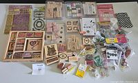 Wide view of all crafting and scrapbooking supplies showing stamps, beads, and accessories in various packaging and containers.