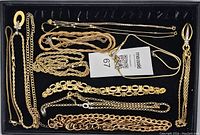 Top-down photo showing 5 gold tone costume jewelry necklaces in various chain styles placed on black background with seller tag.