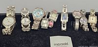 All 8 ladies silvertone watches arranged in a row