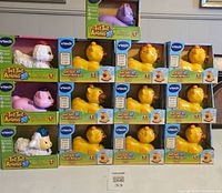 Photo showing multiple boxed yellow giraffe toys and three boxed French animals (poodle, lamb, and cat) in original packaging.