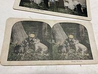 Stereoview card titled 'Weary Hunters' showing a man resting under a tree in outdoor clothes.