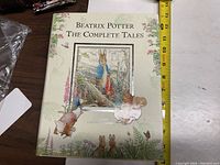 Front cover of Beatrix Potter The Complete Tales book showing detailed illustration of characters and nature scene.