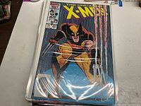 Photo showing front cover of The Uncanny X-Men #207 comic book featuring Wolverine in rainy background with claws extended.