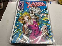 Front cover of Uncanny X-Men #214 comic book in protective sleeve showing characters in an action scene.