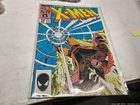 Image showing The Uncanny X-Men comic book issue 221 in a protective sleeve with visible colorful cover artwork depicting action characters.