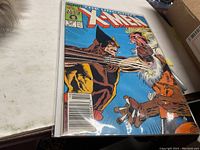 Comic book Uncanny X-Men #222 in plastic sleeve on a table.