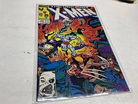 Photo of Uncanny X-Men #238 comic book front cover in protective sleeve featuring multiple X-Men characters