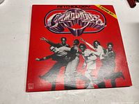 Front cover of The Commodores Anthology 2-record vinyl album. Bright red background with band members posing and album title prominently displayed.