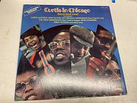 Front cover of the Curtis In Chicago album showing portraits of artists including Curtis Mayfield and Jerry Butler.
