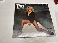Front cover of Tina Turner's Private Dancer record album showing Tina Turner sitting with legs extended.